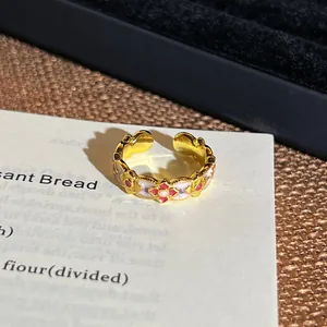 Detaillierte Makroansicht eines goldenen Vintage-Rings mit roten Ölgemälde-Blumenmustern