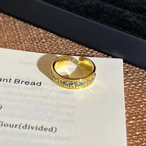 Detailansicht eines goldenen Vintage-Rings mit blauem floralem Ölgemälde-Muster.