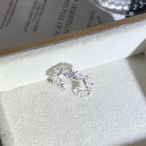Vista detallada de un elegante anillo abierto de flores rosas con acentos de cristal