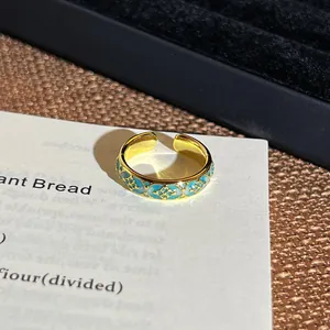 Makroaufnahme eines Vintage-Goldrings mit detaillierten blauen Emaille-Blumenmustern.