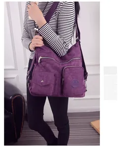 Große lila Oxford-Stoff-Umhängetasche mit mehreren Taschen, an einem Model gezeigt