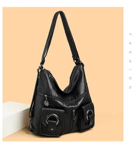 Detail van zwarte leren motorstijl hobo-tas met meerdere ritszakken