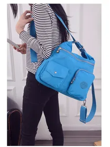 Große hellblaue Oxford-Stoff Umhängetasche mit mehreren Taschen, von einem Model getragen