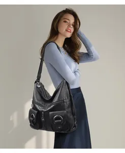 Detailweergave van een vintage zwart zachtleren hobo tas met meerdere ritszakken