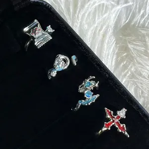 Detailansicht eines Ring-Sets mit Drachen-, Kreuz- und Pfotenmotiven auf schwarzem Samt.