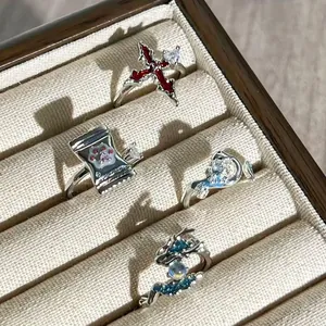 Detailansicht von vier einzigartigen Themenringen mit Kreuz- und Drachendesign in einer Box
