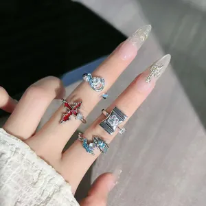 Nahaufnahme von Ringen mit Kreuz-, Drachen- und Pfotenabdruck-Designs an der Hand.