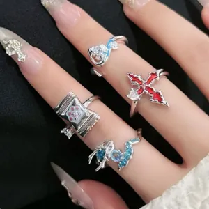 Detailansicht einzigartiger silberner Ringe mit Katzenpfote, gotischem Kreuz und Drachen