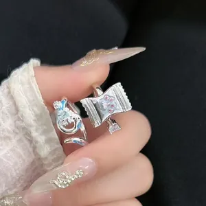 Detaillierte Nahaufnahme von Silberringen mit Pfotenabdruck-Bonbon- und Drachendesign.