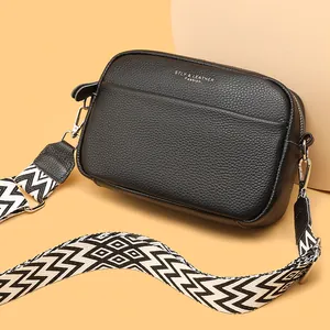 Black genuine leather crossbody bag with stylish wide geometric patterned strap.