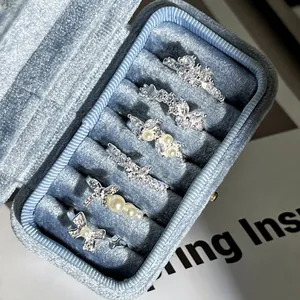 Detailansicht von Ringen mit Perlen und Strassschleifen in einer blauen Samtbox