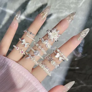 Close-up of elegant French retro pearl and butterfly rings set on manicured hand