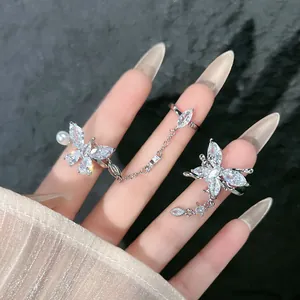 Detail view of sparkly butterfly connected ring with delicate tassels and rhinestones.