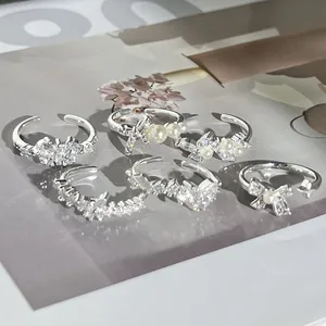 Detailansicht von versilberten Ringen mit eleganten Perlen- und Strass-Schleifendesigns.