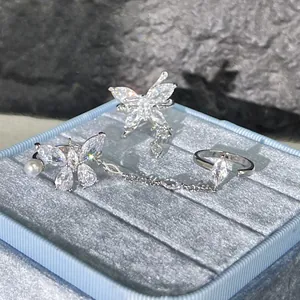 Detailed macro view of silver butterfly connected rings with crystals on blue velvet box