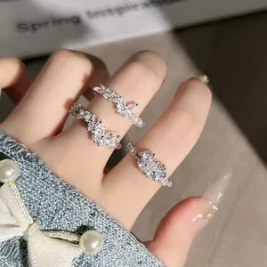 Detailansicht von drei eleganten silbernen Schmetterlings- und Blumen-Kristallringen