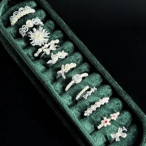 Detail showing a collection of French vintage pearl and crystal rings in a velvet box