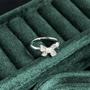 Detailed macro view of a vintage silver pearl bow ring set against green velvet