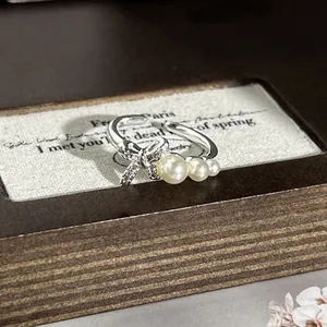 Elegante Detailansicht eines silbernen Schleifenrings mit Kristallen und Perlen