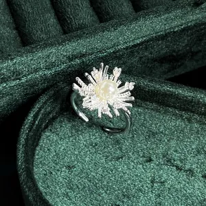 Detail showing a retro silver ring with a pearl center and sparkling starburst motif.