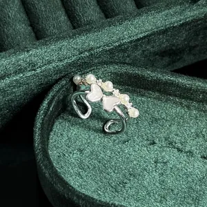 Detail view of a vintage French style pearl bow ring on dark green velvet
