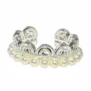 Detailed macro shot of an elegant crown lace ring featuring white pearls and silver design.