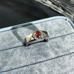 Macro detail of a silver ring with a pomegranate red gemstone in a blue velvet box