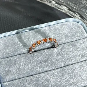 Macro detail view of an elegant adjustable silver ring set with pomegranate red stones