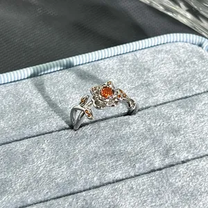 Exquisite detail of a silver floral ring featuring a vibrant garnet-red center stone.