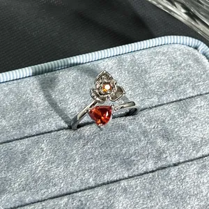 Detailed macro view of the flower and garnet red heart stone on an adjustable open ring
