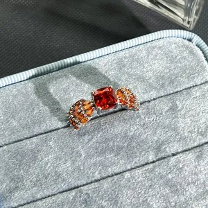 Detailed close-up of a luxury open ring featuring a vibrant garnet red center stone.