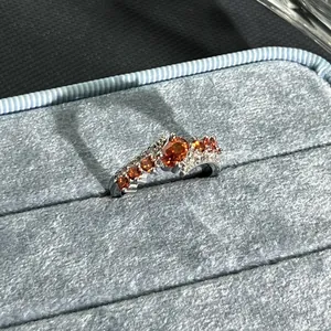 Detailed macro view of an elegant silver open ring with vibrant garnet red stones.