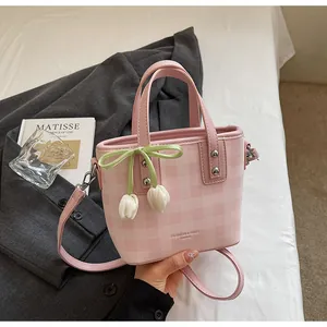 Détail d'un sac seau rose à carreaux avec breloques tulipes et bandoulière