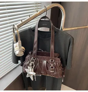 Chic dark brown glossy shoulder bag detail with silver star charm and vintage leather buckles