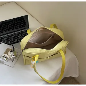 Vue détaillée montrant l'intérieur spacieux et la poche zippée du sac fourre-tout jaune.