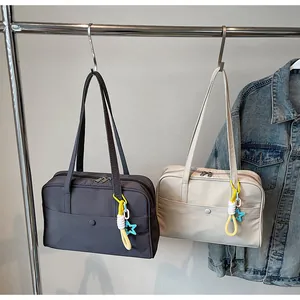 Gros plan de grands sacs fourre-tout minimalistes gris et blanc cassé suspendus à un portant.