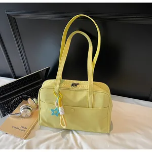 Sac fourre-tout jaune minimaliste pour femme avec pendentif étoile sur table