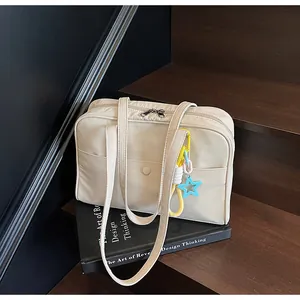 Gros plan d'un sac cabas en toile crème avec breloque étoile sur bois
