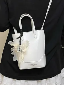 Stylish white leather bucket handbag with decorative flower charm and shoulder strap