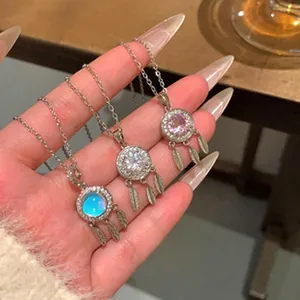Primer plano de collares atrapasueños con piedra lunar y plumas
