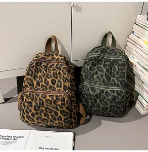 Detailed view of two leopard print backpacks in brown and green colors for students