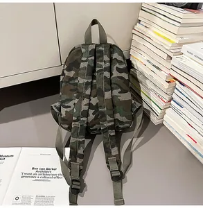 Detailed back view of a trendy camouflage canvas backpack next to a stack of books