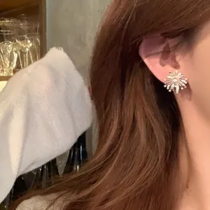Close-up of elegant silver fireworks earrings with a center pearl and zircon accents