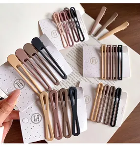 Detalle de pinzas para el cabello mate en tonos tierra presentadas en tarjetas artesanales
