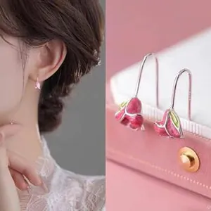 Close-up detail of elegant pink enamel tulip flower earrings for women on pink box