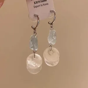 Detail view of elegant copper zircon dangle earrings with translucent round discs.