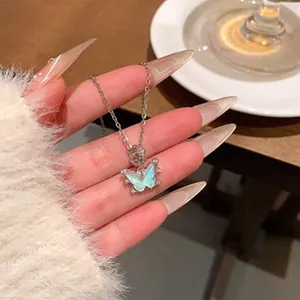Detalle del colgante de mariposa de piedra lunar con piedras brillantes en cadena.