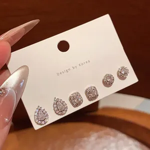 Detail view of elegant micro-pave stud earrings set featuring drop and round stones