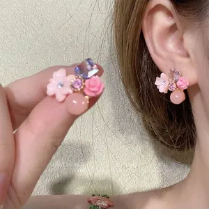 Elegant Mori-style pink floral earrings with crystal and pearl details on model