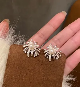 Macro view of silver-tone fireworks stud earrings with white pearls and zircons.